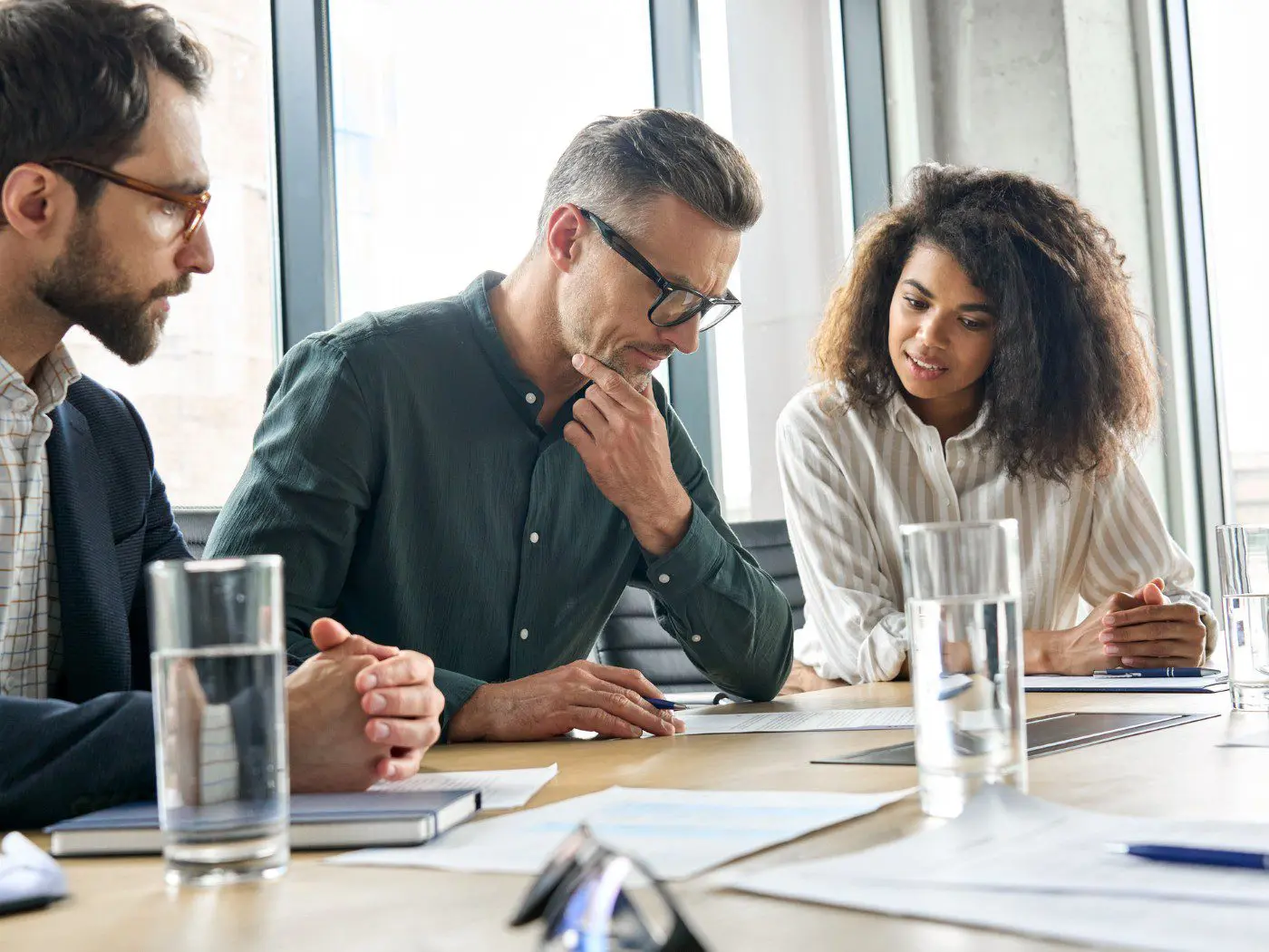 Team discussing documents in a meeting room.
